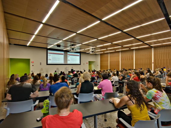 students in a lecture style classroom facing the projector